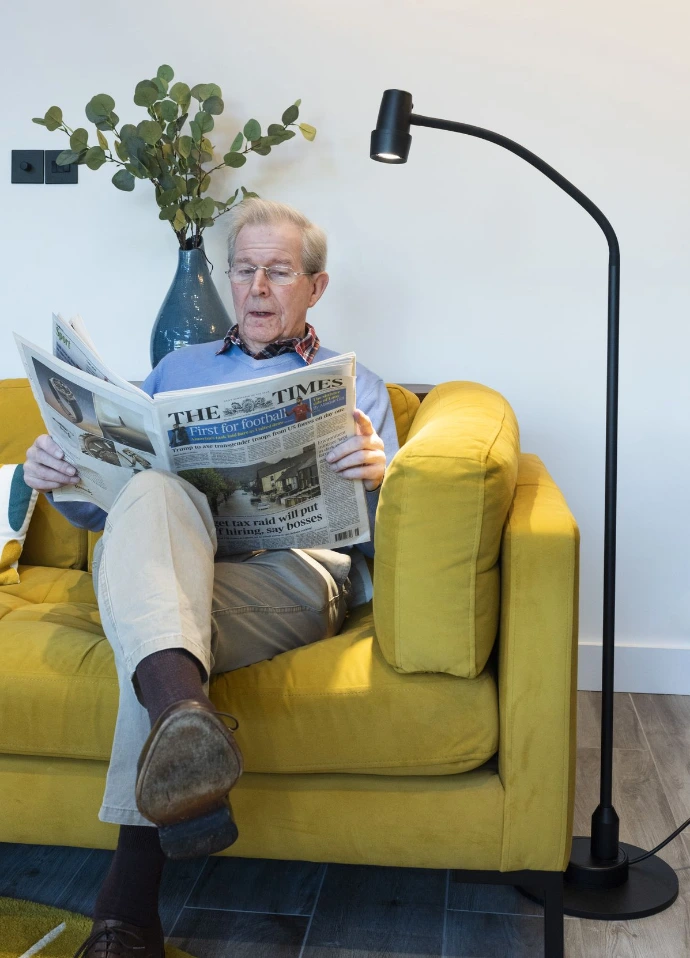 Man reading comfortably with an Omnilux specialist reading light